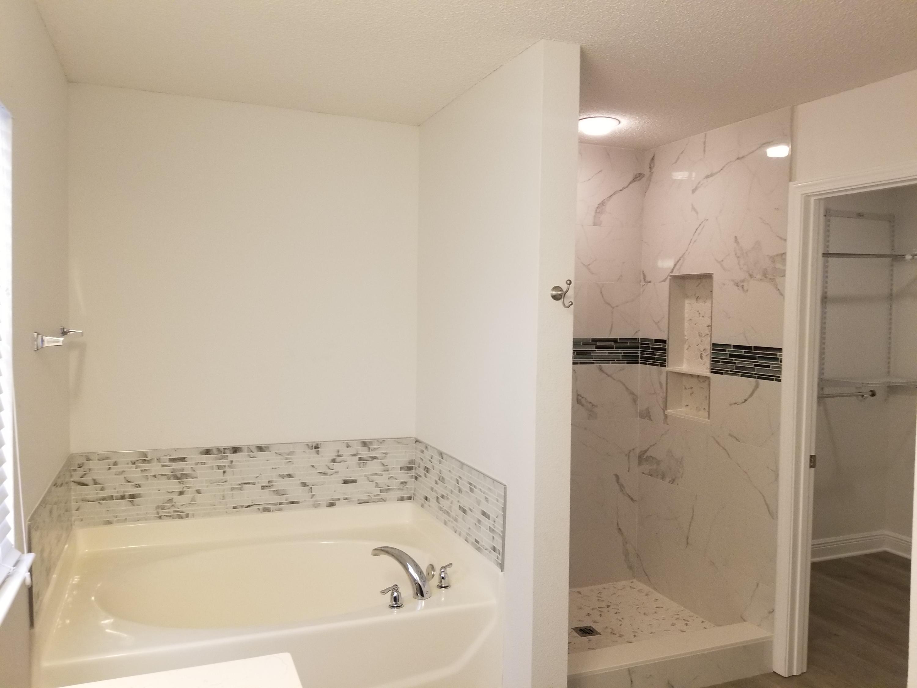 6673 Redfield Street Navarre, FL 32566 - Photo 21 of 32 a bathroom with a bathtub and a shower