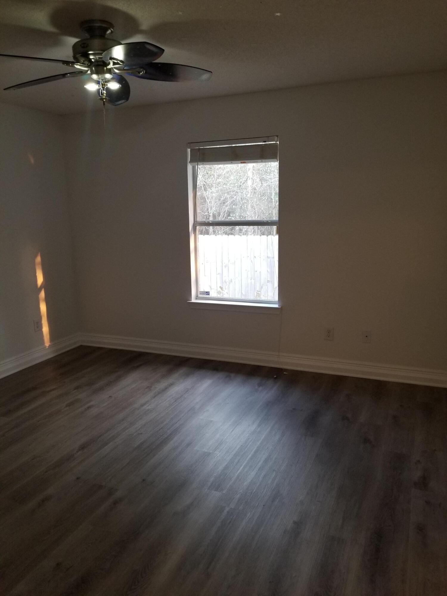 6673 Redfield Street Navarre, FL 32566 - Photo 25 of 32 wooden floor in an empty room with a window