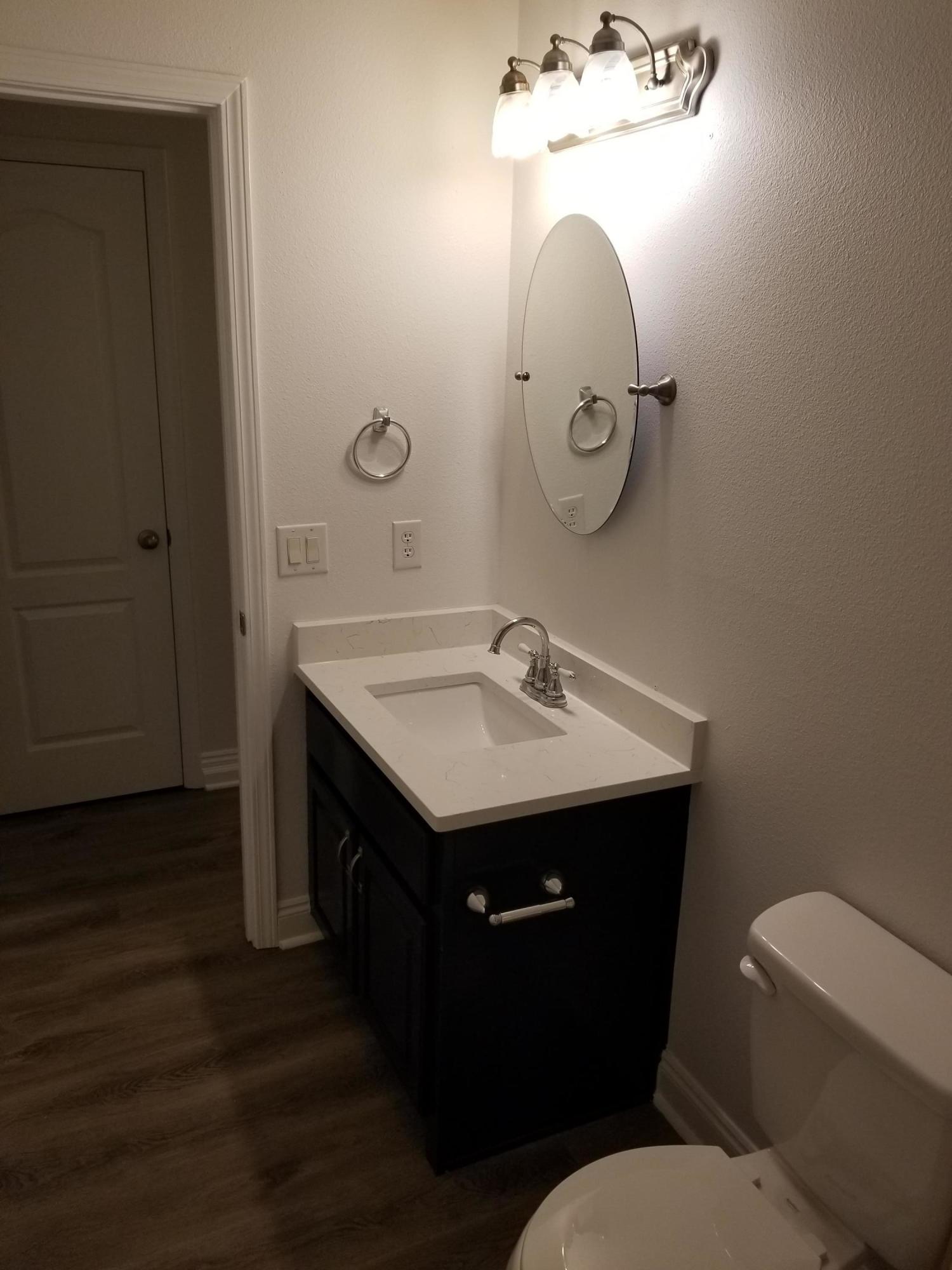 6673 Redfield Street Navarre, FL 32566 - Photo 26 of 32 a bathroom with a toilet sink and mirror