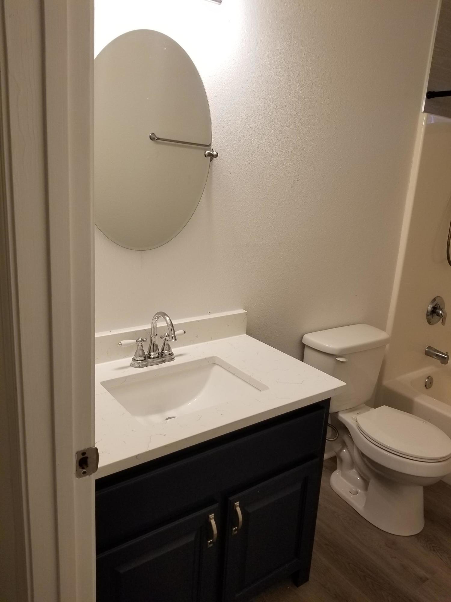 6673 Redfield Street Navarre, FL 32566 - Photo 28 of 32 a bathroom with a sink vanity mirror and toilet