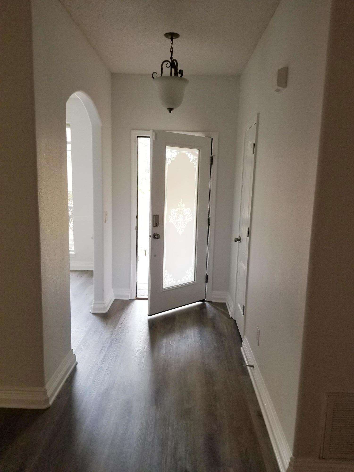 6673 Redfield Street Navarre, FL 32566 - Photo 3 of 32 wooden floor in an empty room with a window