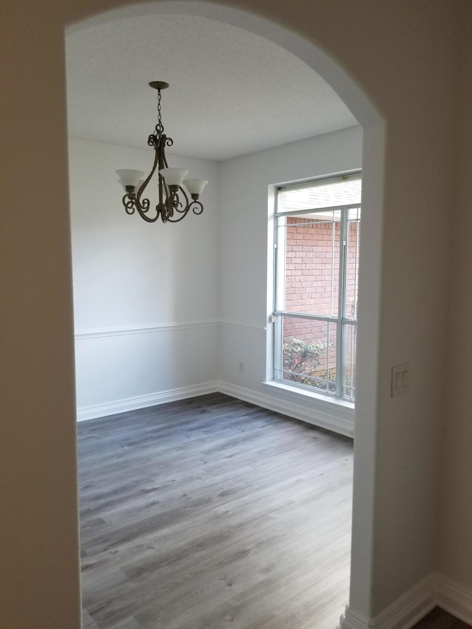 6673 Redfield Street Navarre, FL 32566 - Photo 4 of 32 wooden floor in an empty room with a window
