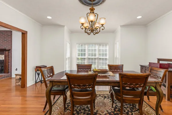 a kitchen with stainless steel appliances granite countertop a refrigerator a sink dishwasher a stove and white countertops with wooden floor
