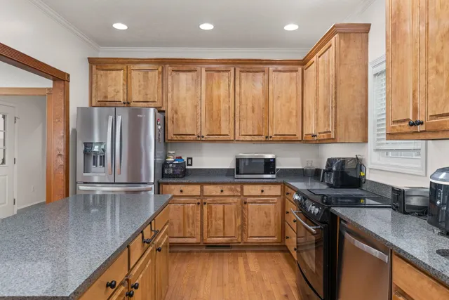 a kitchen with stainless steel appliances granite countertop a refrigerator sink and cabinets