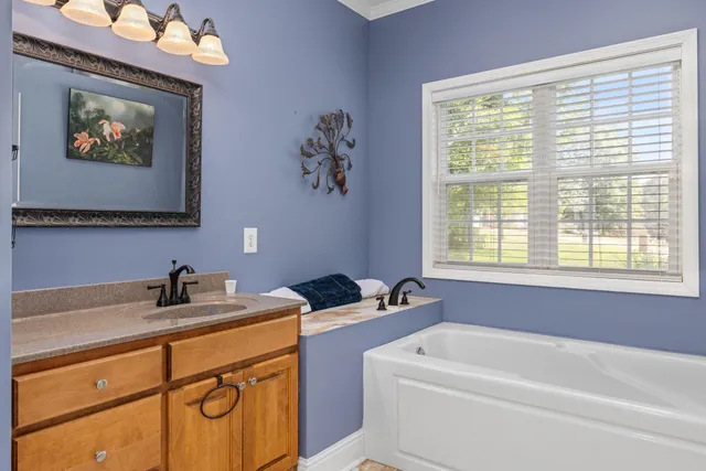 a bathroom with a bathtub a sink and a window