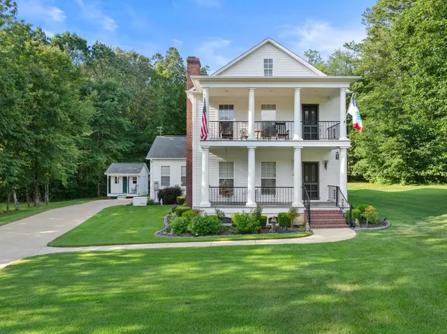 a front view of a house with a yard and trees