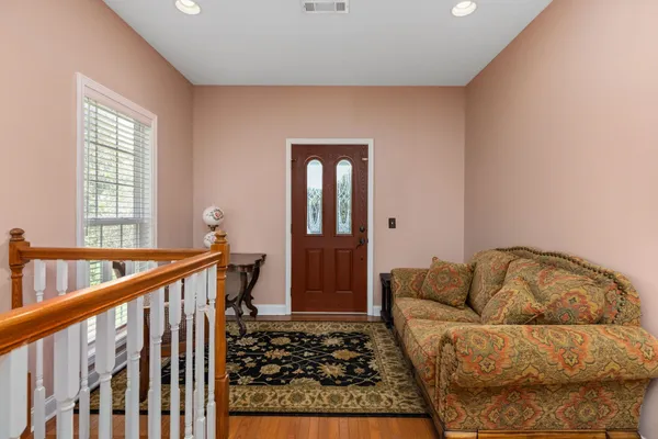 a dining room with wooden floor a chandelier a glass table and chairs