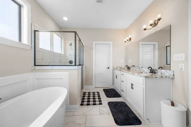 a bathroom with a sink a toilet a mirror and shower