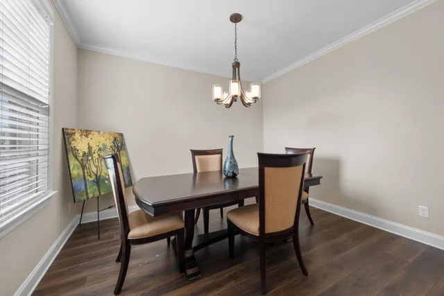 a view of a dining room with furniture a chandelier and wooden floor