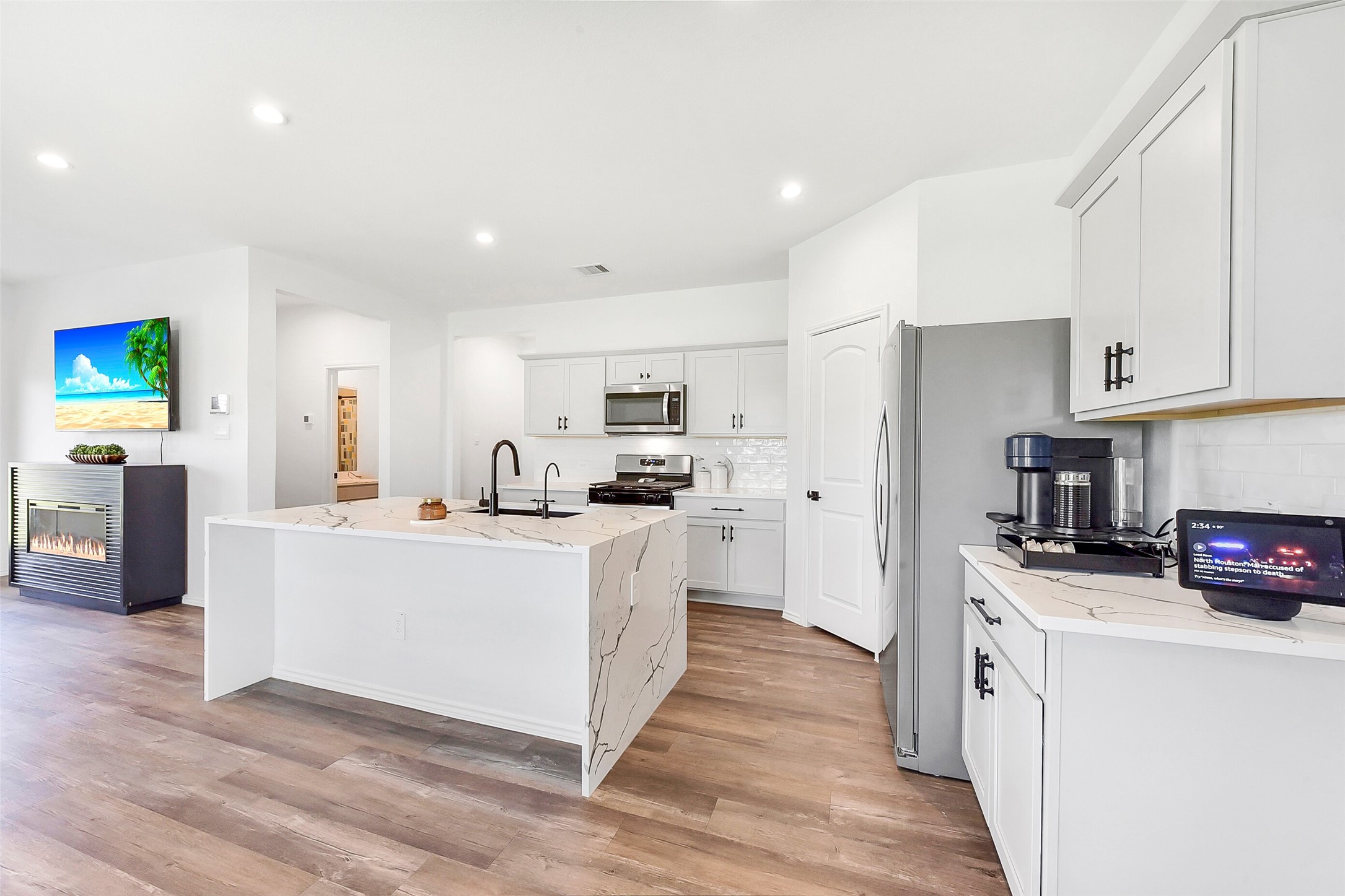 24222 Sandstone Valley Ln Spring Spring, TX 77373 - Photo 10 of 32 a kitchen with white cabinets and stainless steel appliances