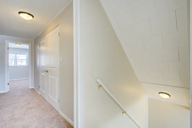 a view of a hallway with closet and wooden floor