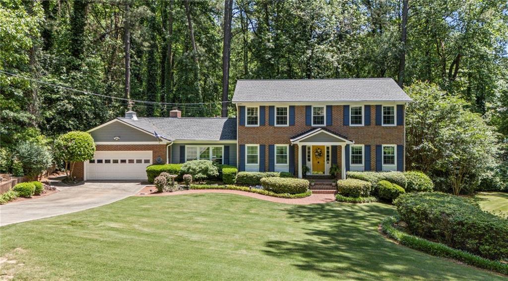 a front view of a house with yard and green space
