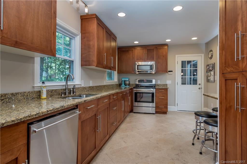 4749 Gaynor Road Charlotte, NC 28211 - Photo 7 of 24 a kitchen with stainless steel appliances granite countertop a stove top oven a sink dishwasher a dining table and chairs with wooden floor