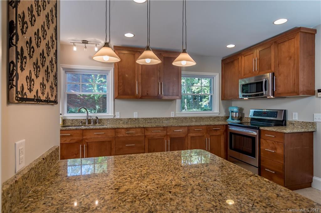 4749 Gaynor Road Charlotte, NC 28211 - Photo 8 of 24 a kitchen with stainless steel appliances granite countertop wooden cabinets a stove top oven a sink and dishwasher