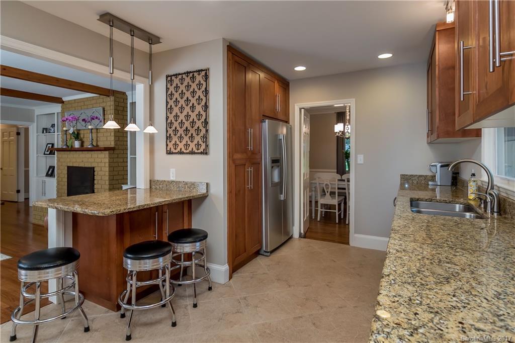 4749 Gaynor Road Charlotte, NC 28211 - Photo 10 of 24 a kitchen with kitchen island granite countertop wooden cabinets and counter space