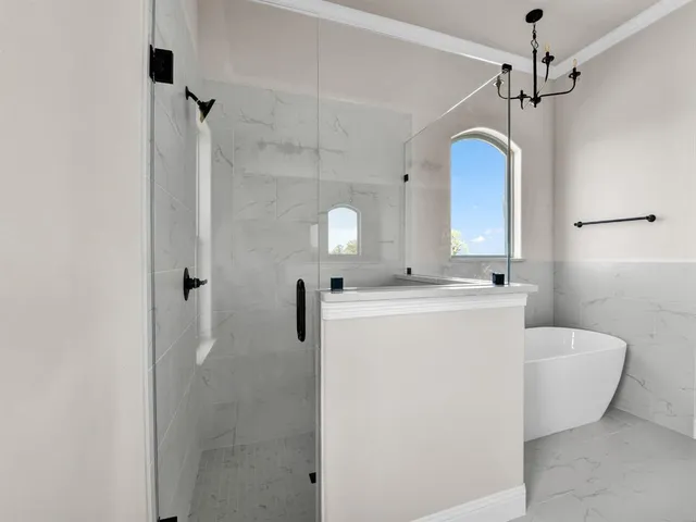 a bathroom with double vanity sinks a vanity a tub and a mirror
