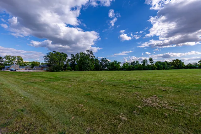 a view of a big yard with a house in the background