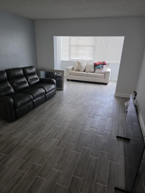 3130 Holiday Springs Boulevard, Unit 104 Margate, FL 33063 - Photo 2 of 7 a living room with furniture and a window