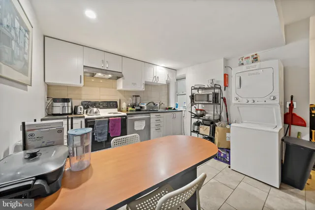 a kitchen with a refrigerator a stove and white cabinets