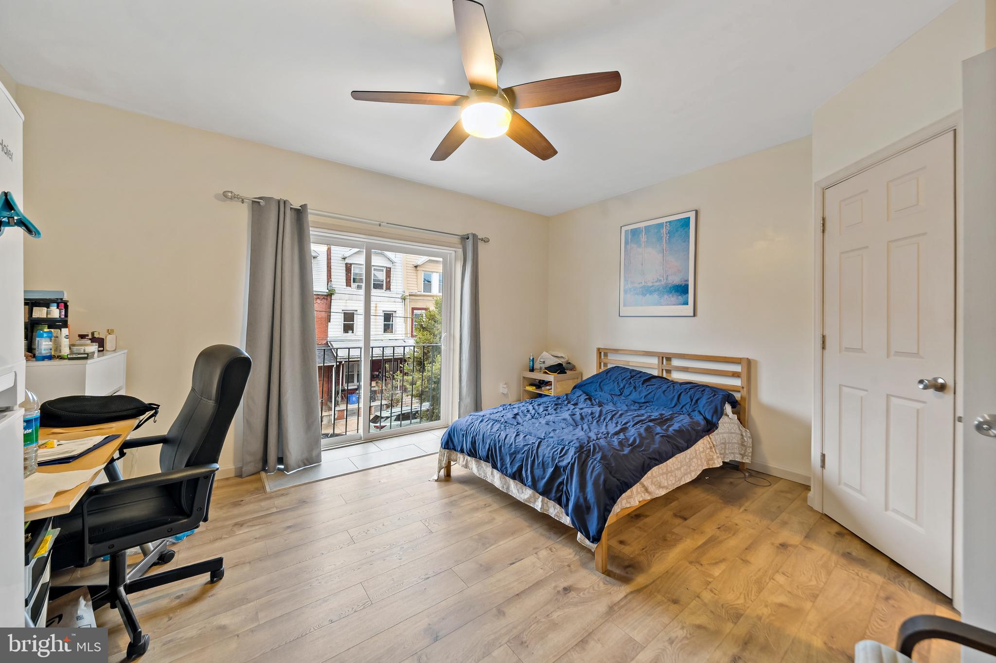 653 North 33rd Street Philadelphia, PA 19104 - Photo 19 of 28 a bedroom with a bed a desk and chair with wooden floor