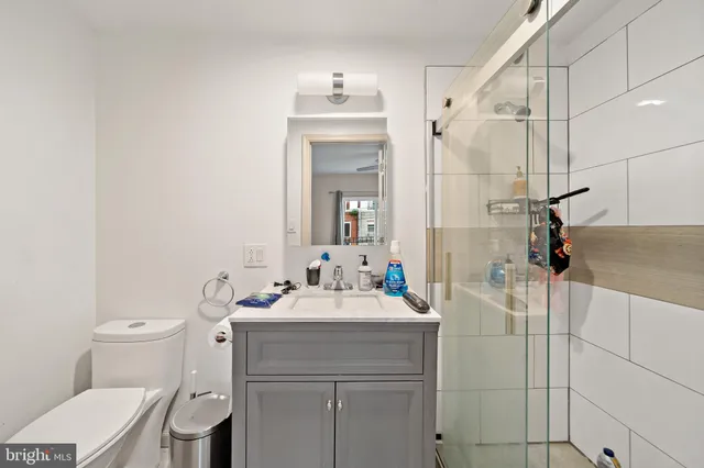 a bathroom with a sink vanity mirror and toilet