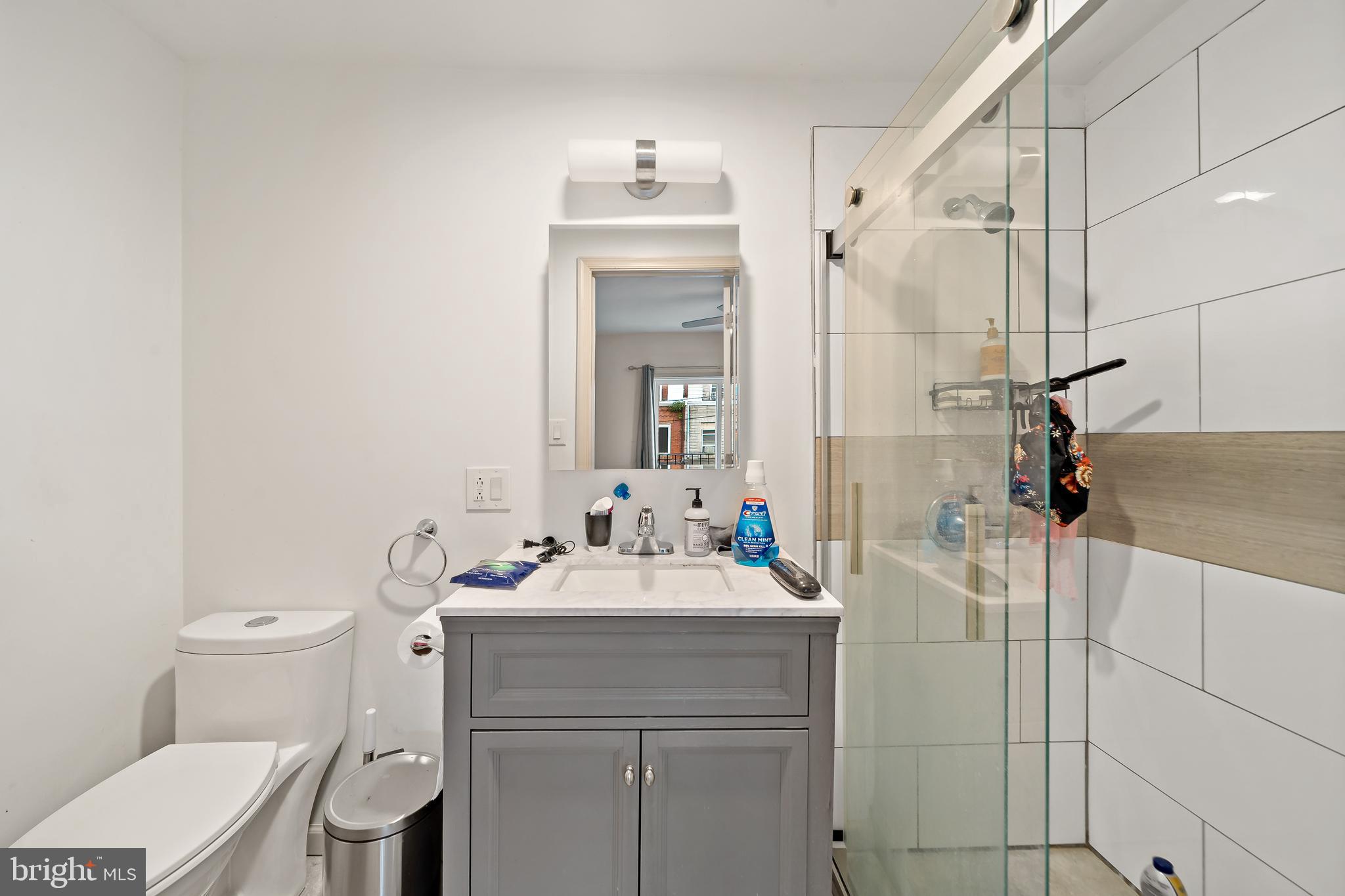 653 North 33rd Street Philadelphia, PA 19104 - Photo 21 of 28 a bathroom with a sink vanity mirror and toilet