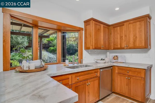 a kitchen with stainless steel appliances granite countertop a sink and a wooden cabinets