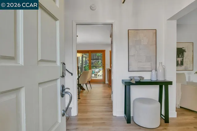 a hallway with white cabinets and wooden floor