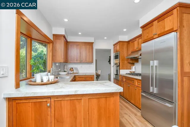 a kitchen with stainless steel appliances granite countertop a sink and a refrigerator