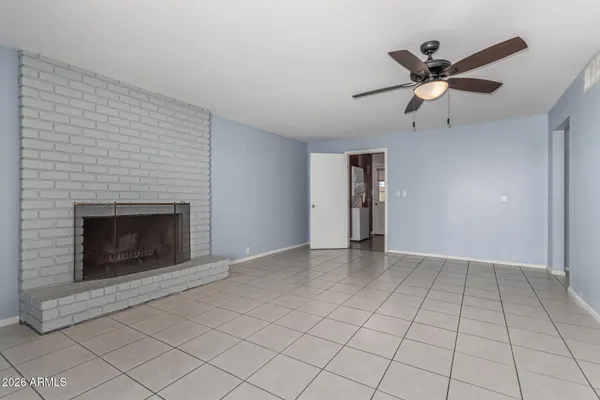 a view of an empty room with cabinet and a fireplace