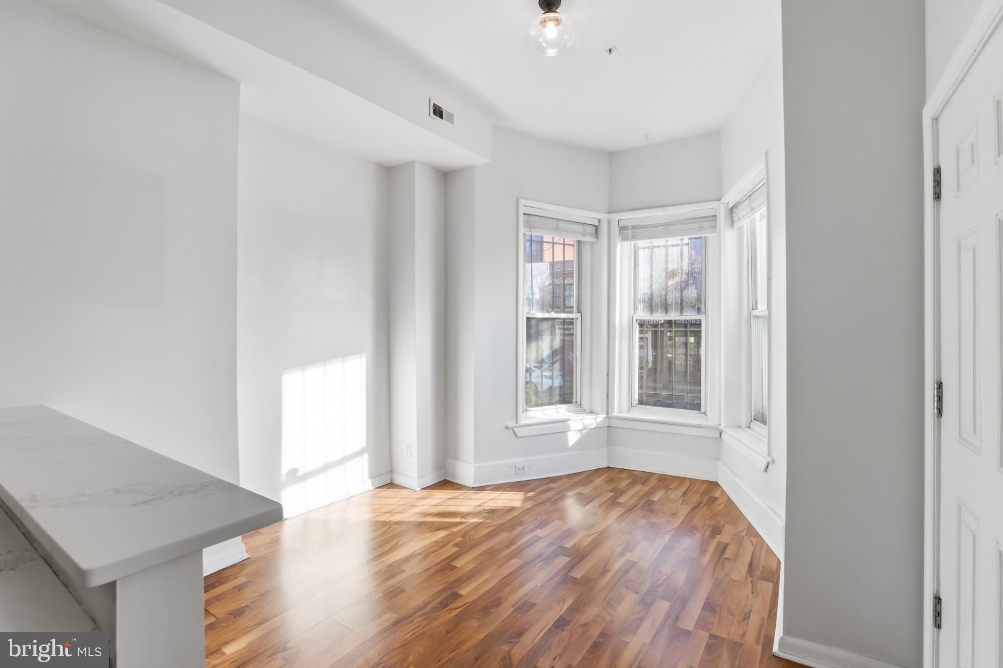 1912 9th Street Northwest, Unit 1 Washington, DC 20001 - Photo 9 of 18 a view of an empty room with wooden floor and a window