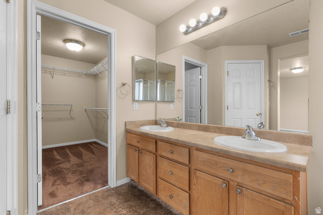 3053 Sage Loop, Unit B1 Lehi, UT 84043 - Photo 13 of 25 Dual vanity with light wood-finish cabinetry and integrated sinks, featuring a full-width mirror and polished chrome fixtures