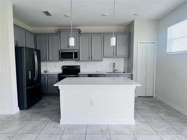 a kitchen with cabinets and stainless steel appliances