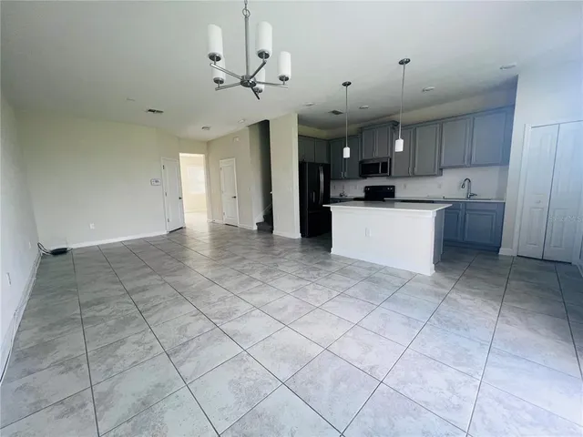 a view of a kitchen with kitchen island stainless steel appliances cabinets and a sink