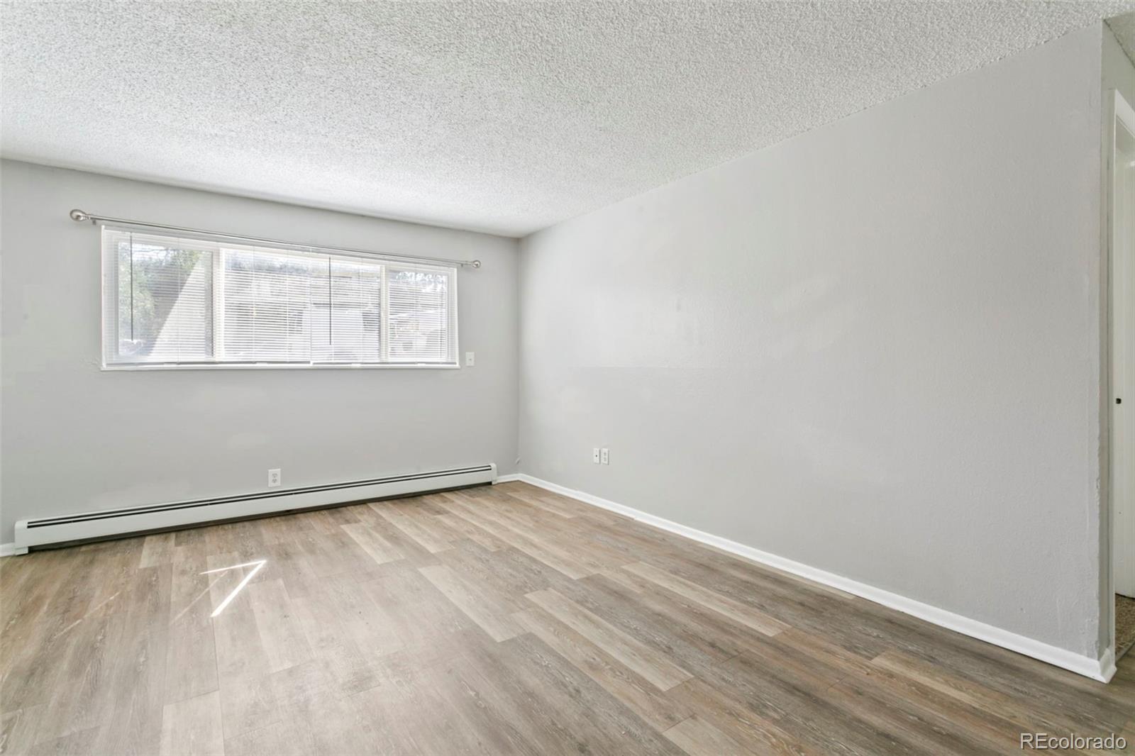 330 Vehr Drive Colorado Springs, CO 80916 - Photo 6 of 17 an empty room with wooden floor and windows