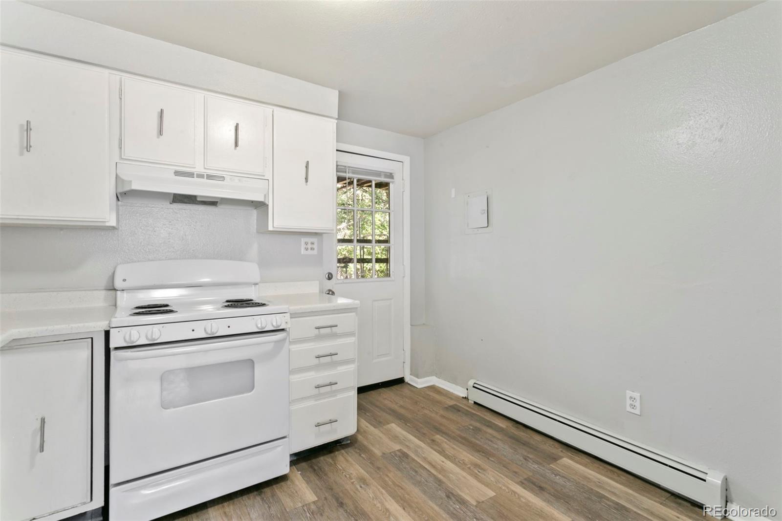 330 Vehr Drive Colorado Springs, CO 80916 - Photo 7 of 17 a kitchen with granite countertop white cabinets and white appliances