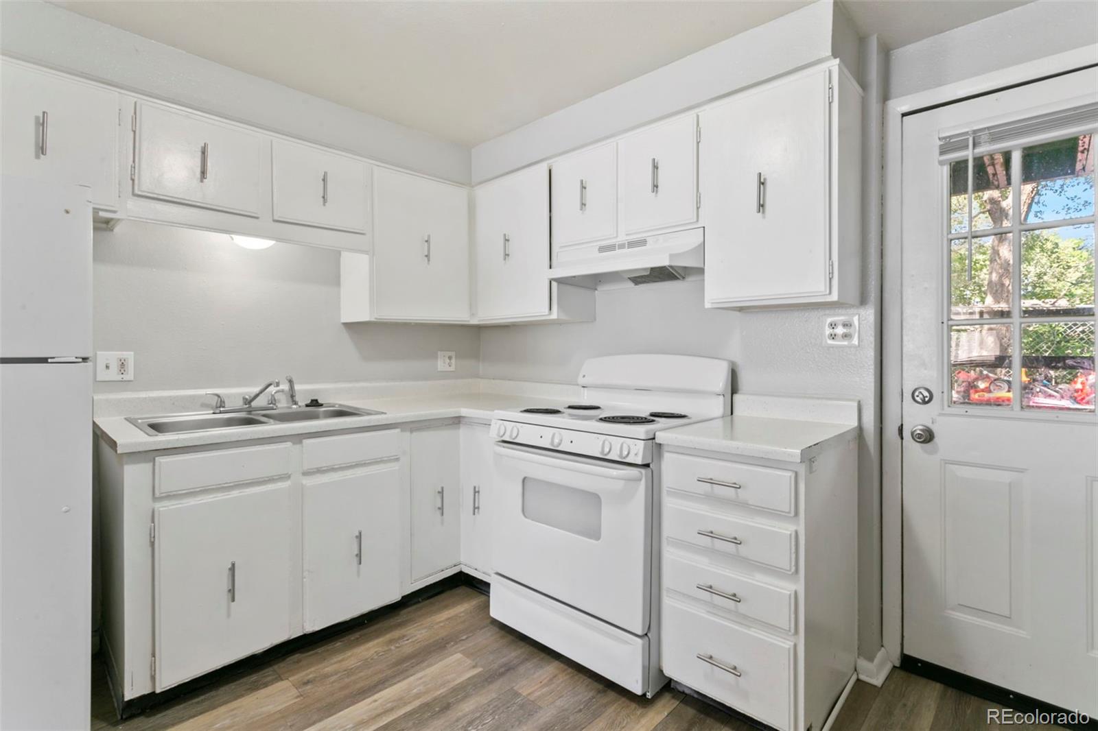 330 Vehr Drive Colorado Springs, CO 80916 - Photo 8 of 17 a kitchen with granite countertop white cabinets and white appliances
