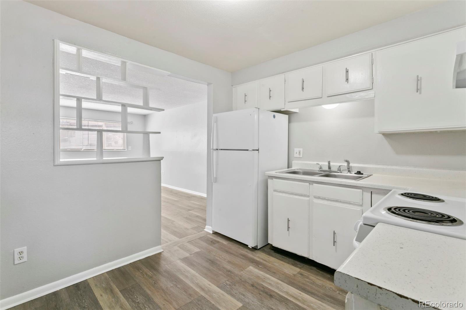 330 Vehr Drive Colorado Springs, CO 80916 - Photo 9 of 17 a kitchen with white cabinets and white appliances