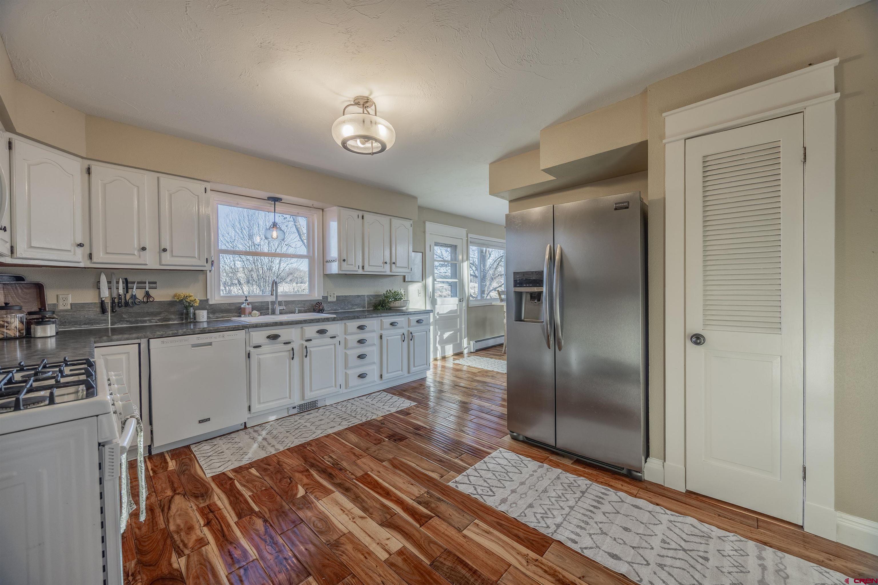 15214 6125th Road Montrose, CO 81403 - Photo 16 of 45 a kitchen with granite countertop a refrigerator sink and cabinets