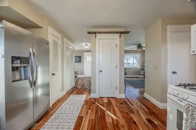 a walk in closet with wooden floor