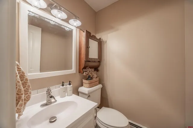 a bathroom with a sink a toilet and mirror