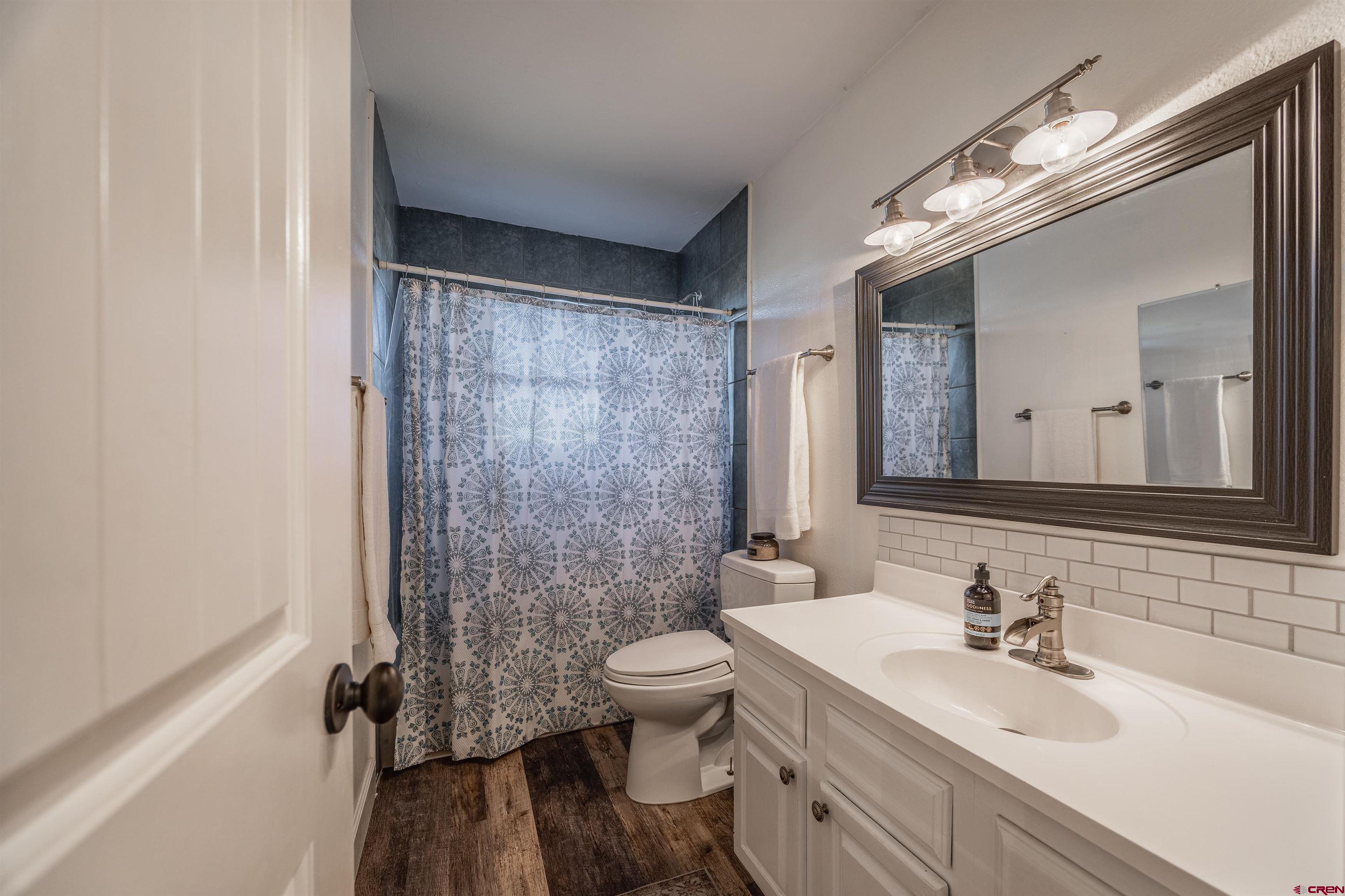15214 6125th Road Montrose, CO 81403 - Photo 31 of 45 a bathroom with a sink a toilet a mirror and shower