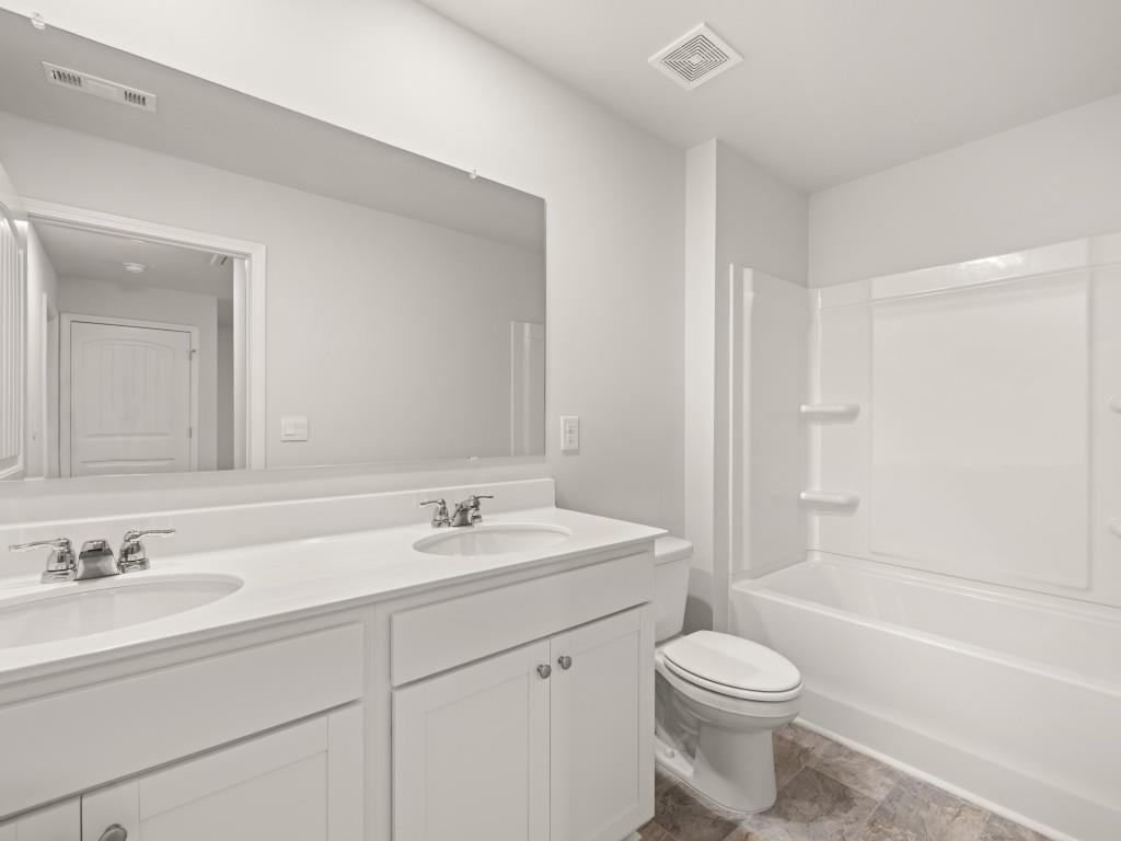 50 Rustin Ridge Dahlonega, GA 30533 - Photo 34 of 42 a bathroom with a toilet a sink a mirror a bathtub and vanity