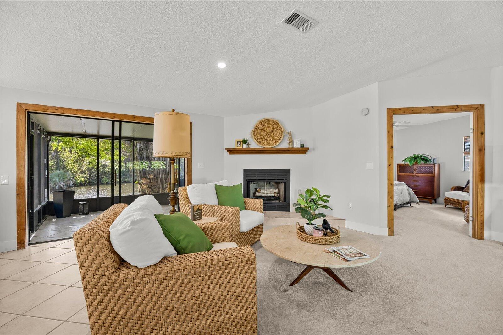 7918 Southeast Paradise Court Stuart, FL 34997 - Photo 11 of 29 a living room with furniture a fireplace and a floor to ceiling window