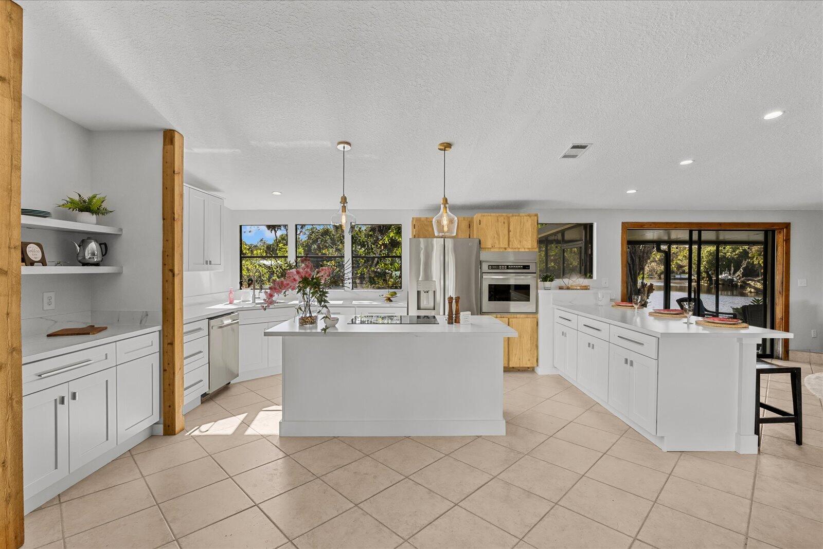 7918 Southeast Paradise Court Stuart, FL 34997 - Photo 22 of 29 a kitchen with stainless steel appliances a white table chairs and a refrigerator