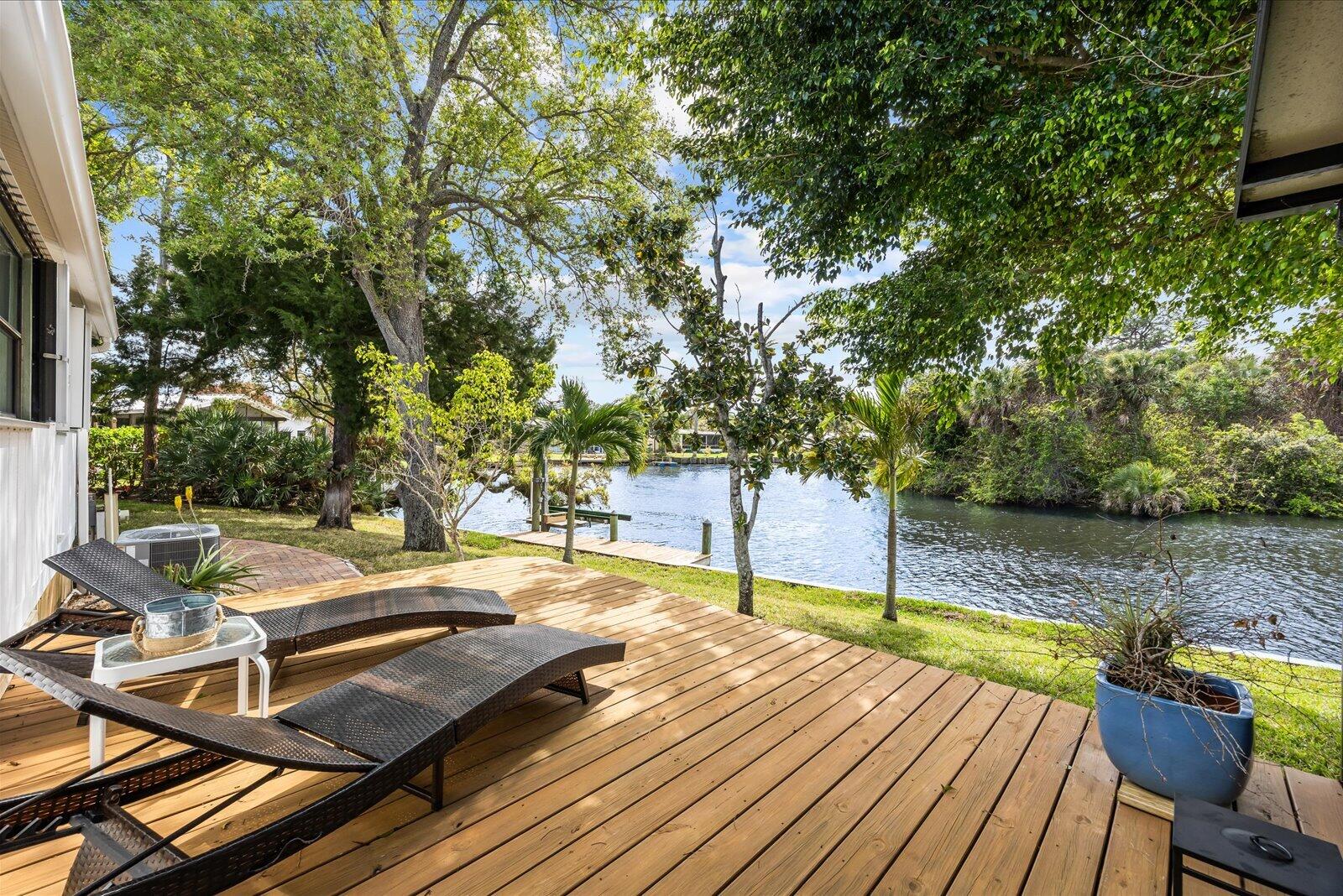 7918 Southeast Paradise Court Stuart, FL 34997 - Photo 5 of 29 a view of a patio with chairs and an umbrella