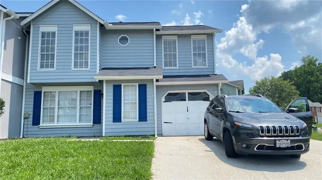 a car parked in front of white house