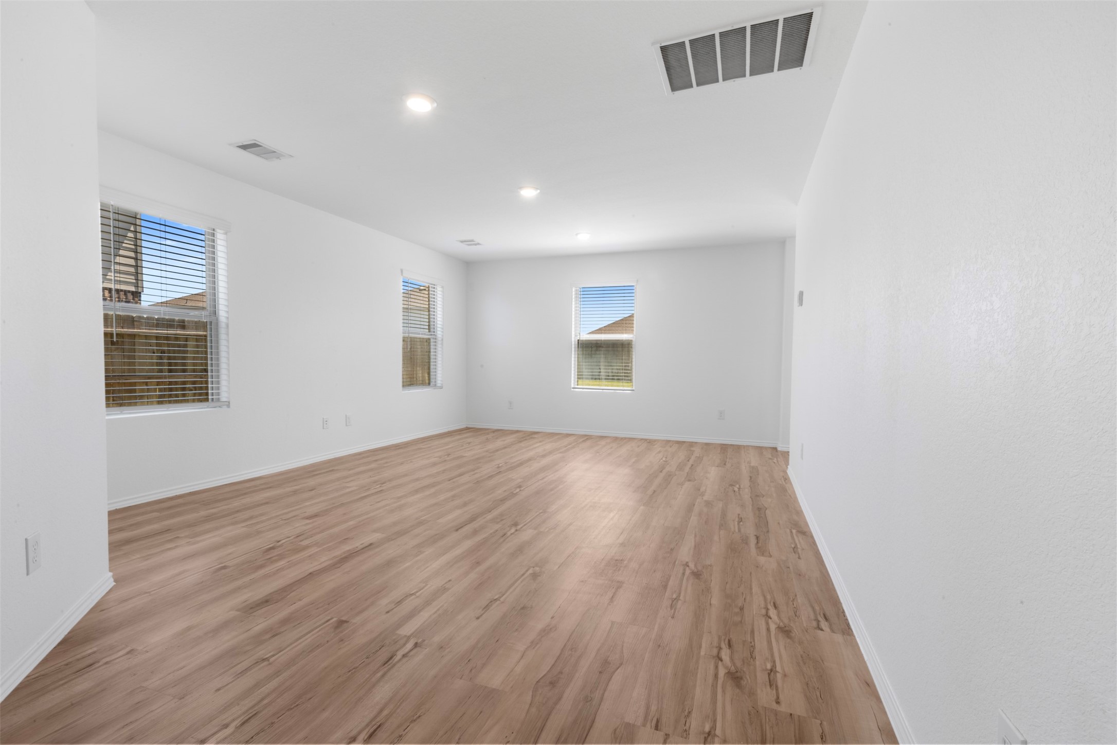 14602 Broadbury Pond Road Rosharon, TX 77583 - Photo 8 of 22 an empty room with wooden floor and windows