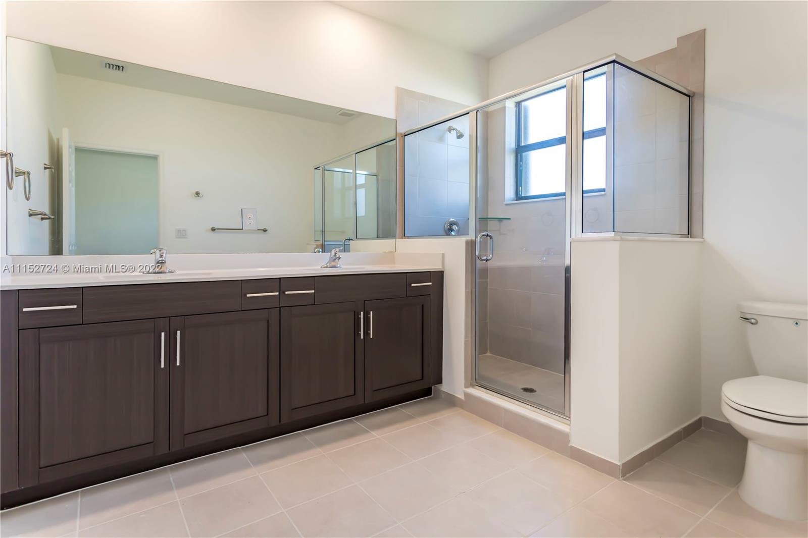 Davie Davie, FL 33314 - Photo 18 of 34 a bathroom with a double vanity sink toilet and shower