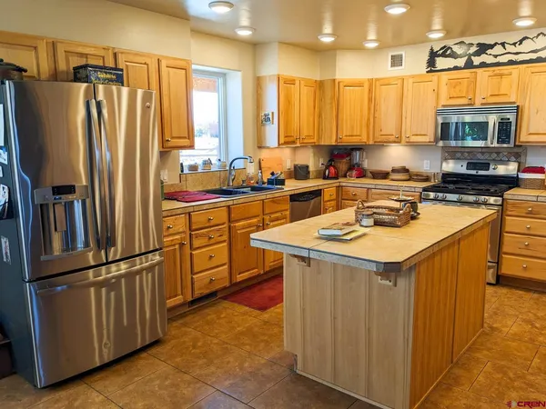 a kitchen with stainless steel appliances granite countertop a refrigerator a sink and a stove